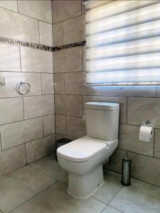 恩潘盖尼Listos Guest House的一间带白色卫生间的浴室和窗户。
