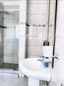 恩潘盖尼Listos Guest House的浴室配有卫生间、盥洗盆和淋浴。