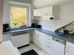 海格尔Stilvolles 4-Bett Appartment的厨房配有白色橱柜和窗户。
