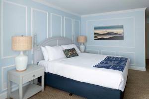 旧金山Coventry Motor Inn的蓝色的卧室配有一张床和一张带台灯的桌子