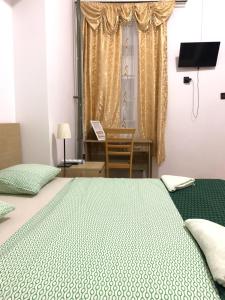 布达佩斯Kecskeméti Rooms的一间卧室配有一张床、一张书桌和一个窗户。