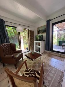 斯泰伦博斯Santika Garden Cottage Stellenbosch的客厅配有沙发和桌子
