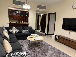 阿卜杜勒国王经济城هافانا المارينا Apartment的客厅配有黑色沙发和桌子
