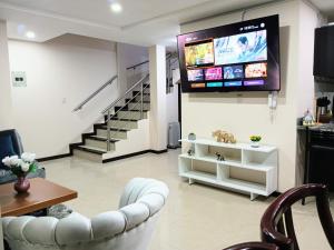 昆卡Departamento Grande con Jacuzzi的客厅配有沙发和墙上的电视