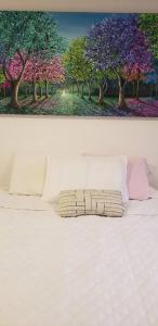 马尼萨莱斯Robles12 El Cable Luxury Highrise的一张床上的照片,上面有一幅树画