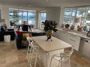 悉尼Shared Beachfront Living的厨房以及带桌椅的起居室。