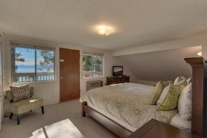 霍姆伍德Evans Lakeview- Hot Tub- Fireplace- Walk To Lake- Minutes to Homewood Resort的卧室配有床、椅子和窗户。