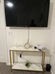 休斯顿Midtown Getaway的墙上的电视机,桌子和时钟