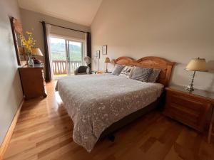 蒙特朗布朗Cozy 2 bedrooms condo with stunning Mont Tremblant mountain and lakeview的一间卧室设有一张床和一个大窗户