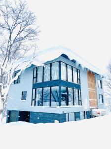 二世古Villa Yin Niseko的前方被雪覆盖的建筑