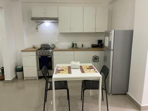 Monte PlataPlataview Apartahotel apt 4C的厨房配有桌椅和冰箱。