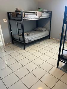 迈阿密Beds & Sheets Little Havana的铺有瓷砖地板的客房内的一张黑色双层床