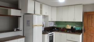 维多利亚Sossai Hostel的厨房配有白色橱柜和白色冰箱。