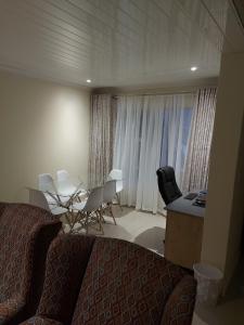 比勒陀利亚紫橄榄宾馆的酒店客房带一张床、一张桌子和椅子