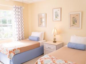 Creek VillagePerfect Island Retreat at Paradise Island Beach Club Villas的一间卧室设有两张床和窗户。