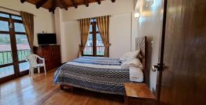 卡尔卡Casa de campo Qhapaq Wasi的一间卧室设有一张床、一台电视和一个窗口。