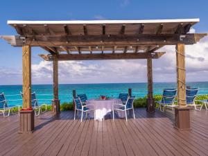 Creek VillageDeluxe Sea View Villas at Paradise Island Beach Club Resort的木甲板上的桌椅