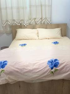 法马古斯塔Grandmother's House的一张白色的床,上面有蓝色的花朵