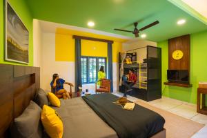 维特利The Hosteller Wayanad的卧室拥有绿色和黄色的墙壁,配有一张床