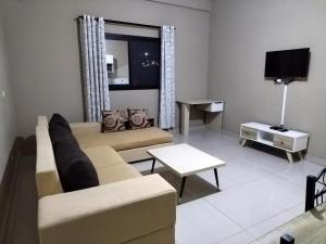 塔那那利佛Milestone City - Appartements à louer的带沙发和电视的客厅