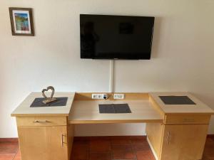 加尔蒂Garni Apart Wallamotta Silvretta Card Premium Betrieb的一张木桌,墙上配有平面电视