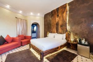 马拉喀什Albakech Boutique Hôtel & Spa的一间卧室配有一张床和一张沙发
