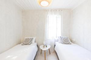 纳夫普利翁Theros Cottage Nafplio的白色的客房配有两张床和一张桌子