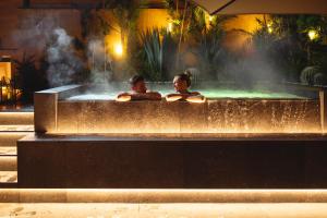 特伦托Hi Hotel - Wellness & Spa的两人在大楼的热水浴缸中