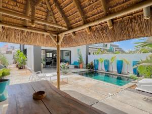 格兰贝伊Résidence Celestial - Premium 3 bedrooms Villa with volcanic stone Pool的一座带游泳池和稻草屋顶的别墅