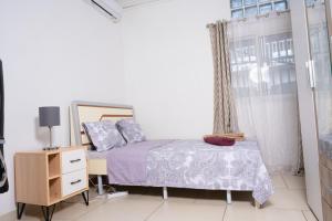 MamoudzouBelle demeure spacieuse 2的一间卧室配有一张床、一个梳妆台和一扇窗户。