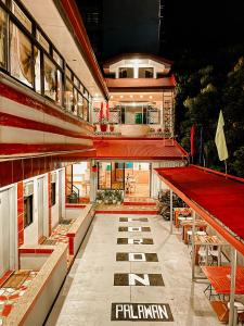 科隆Mario's Travellers Inn的一座带桌子和长凳的红色屋顶建筑