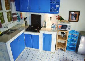 基苏木Ose Cottages的一间小厨房,内配蓝色橱柜和微波炉