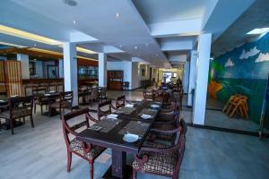 希克杜沃Hotel Wewala Beach的用餐室配有桌椅和壁画