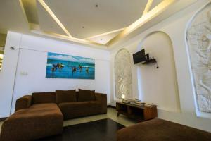 希克杜沃Hotel Wewala Beach的客厅配有沙发和墙上的绘画
