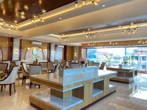 登巴萨City of Aventus Hotel - Denpasar的餐厅设有桌椅和大窗户。