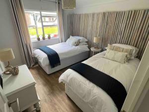 韦伯恩Waterside Lodge, Weybourne, Holt的小型客房 - 带2张床和窗户