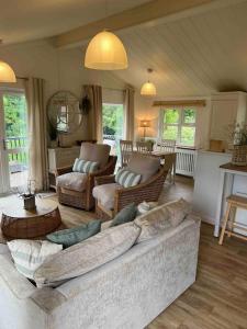 韦伯恩Waterside Lodge, Weybourne, Holt的客厅配有大沙发和椅子