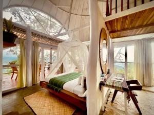 BajawaManulalu Jungle的一间带天蓬床的卧室,位于带窗户的房间内