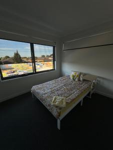 St AlbansComfortable bedroom in a beautiful suburb的一间卧室设有一张床和一个大窗户