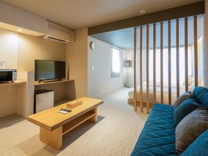 奈良Hotel Rokune的客厅配有蓝色的沙发和电视