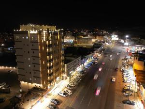 Al Namasقمم بارك Qimam Park Hotel 6的街道,夜间有汽车和建筑