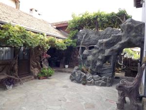 德里亚诺沃Самостоятелна Вила в Хаджи Марковата къща за гости в Дряново的室外庭院设有树木环绕的岩石结构