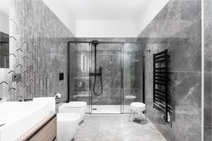 都灵Q71 TIMELESS SUITES的带淋浴、卫生间和盥洗盆的浴室