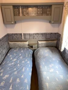 弗利特伍德Haven caravan park Cala gran的小房间,拖车上设有两张床