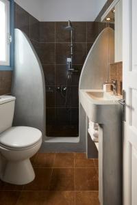 易莫洛林Athiri Santorini Hotel的浴室配有卫生间、盥洗盆和淋浴。