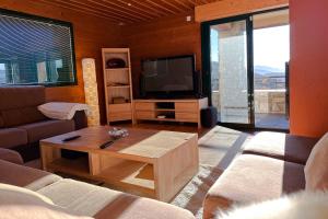 埃安CHALET DE LA COULEE - Chalet de grand standing avec spa offrant une vue sur la vallée的带沙发和电视的客厅