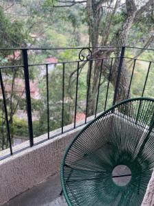 圣安东尼奥-杜皮尼亚尔VILLA ITÁLIA CHALÉ的绿色长凳,位于一个美景阳台