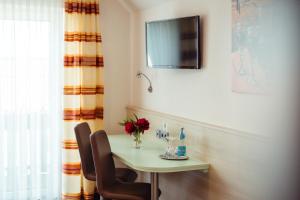Neusorg桑恩塔尔酒店的一张桌子、两把椅子和墙上的电视