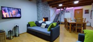 塔尔维西奥la LUNA delle MONTAGNE Charme & SPA Chalet的带沙发的客厅和用餐室