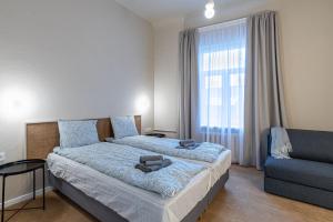 里加Dandelion Apartments Ģertrūdes的一间卧室配有一张床、一张沙发和一个窗口